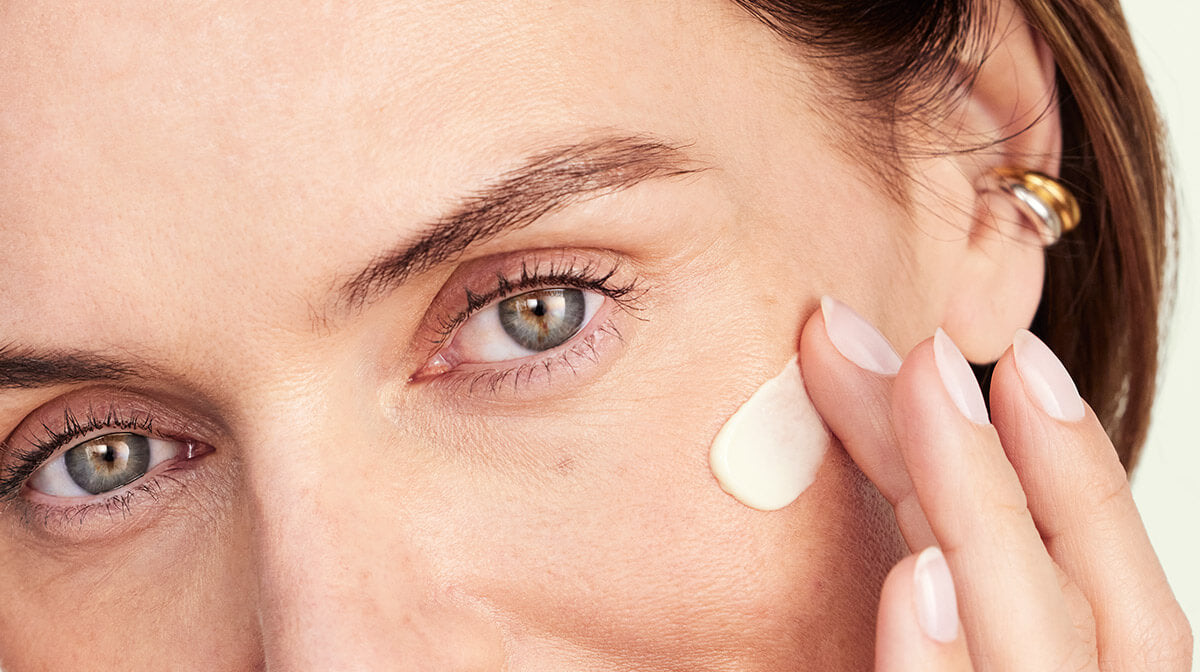 une femme s'appliquant de la crème sur le visage
